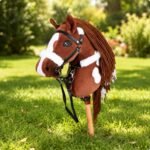 Vosbont stokpaard met fleece hoofdstel op een gazon