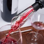 Beluchtende schenktuit die rode wijn in een glas schenkt op een houten dienblad