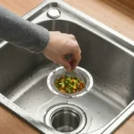 Roestvrijstalen gootsteenzeefmandje met handvat in een gootsteen