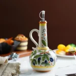 Handbeschilderde keramische olijfoliefles op een eettafel