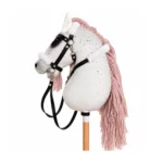 Wit gespikkeld stokpaard met oudroze manen en zwart hoofdstel met witte fleece